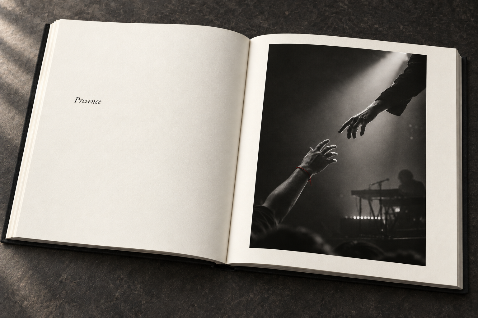 An open ivory book with a quiet Presence title opposite the reaching-hands study: two hands almost meeting in stage light, a crimson wrist thread and a keyboard player behind.