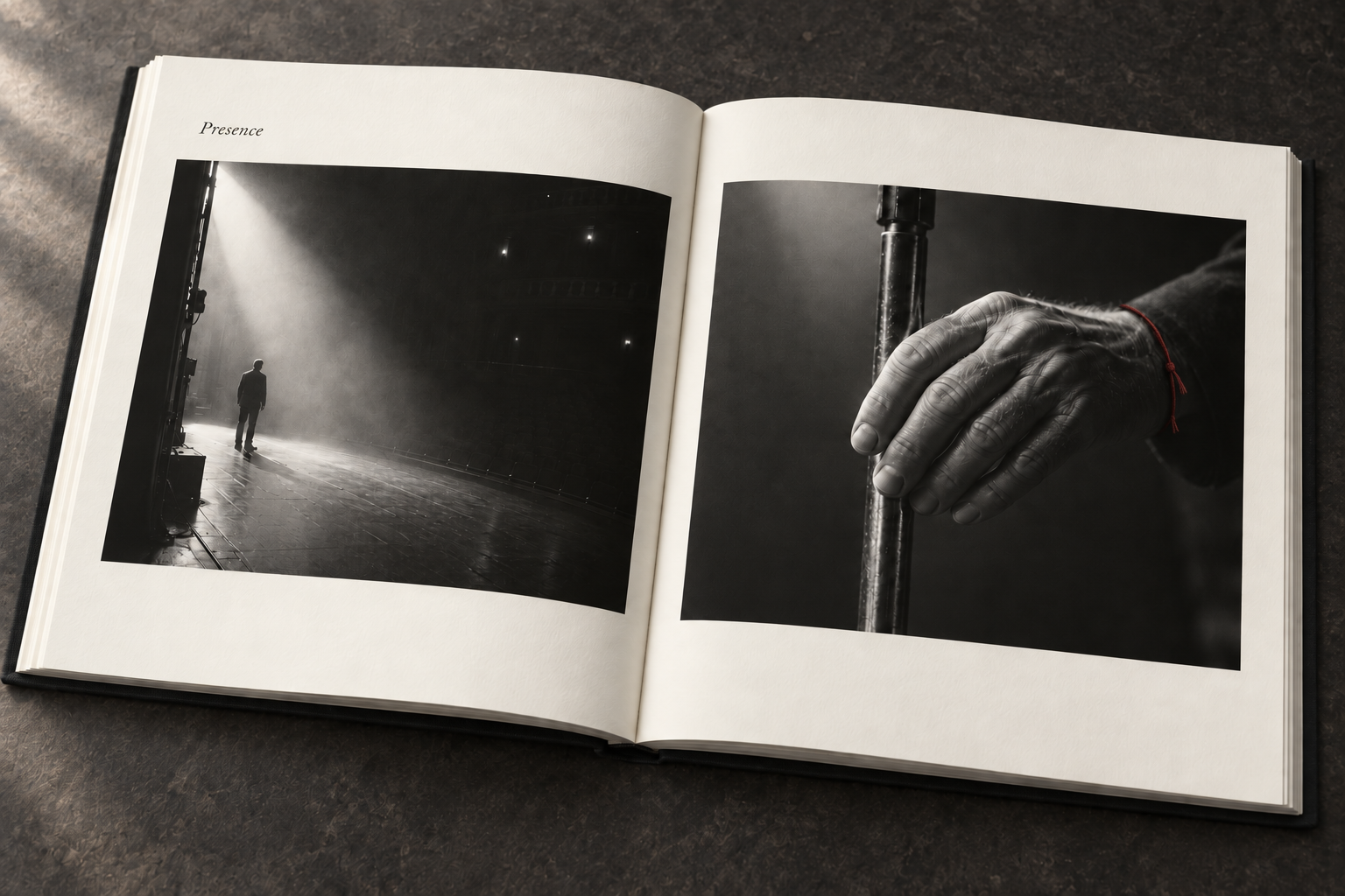 An open ivory art book: a small figure in stage light on the left page and a close study of a hand resting on a microphone stand on the right.